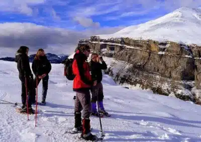 Excursionistas en los Miradores de Ordesa contemplan el valle nevado del Pirineo